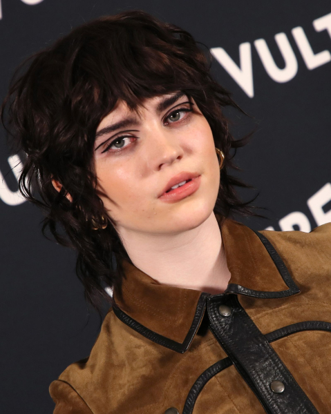 Sophie Thatcher in a short wolf cut wearing a brown suede and leather shirt